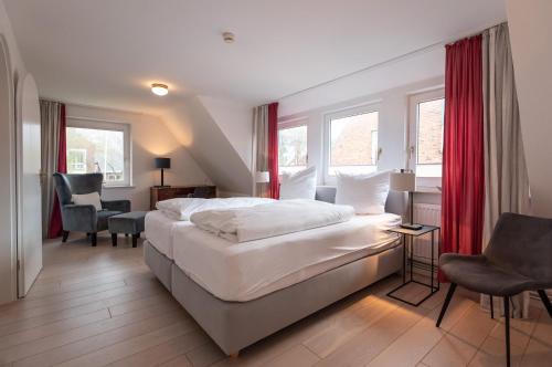 a bedroom with a bed and a desk and chairs at Haus Gorch Fock Strasse in Westerland
