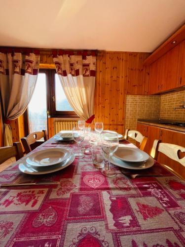 a dining room table with wine glasses on it at Case Vacanza Perron in Sauze dʼOulx