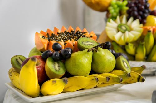a pile of fruit on a plate on a table at Imperial Plaza Hotel in Taguatinga