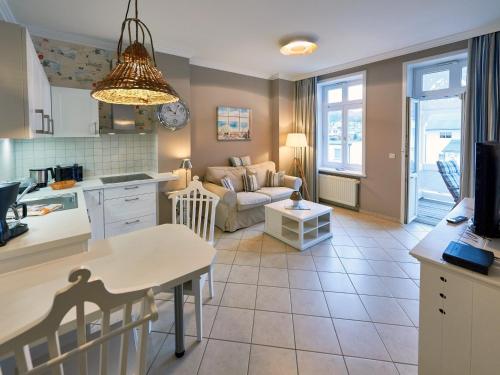 een keuken en een woonkamer met een bank en een tafel bij Villa Fernsicht - Apt. 05 in Ostseebad Sellin