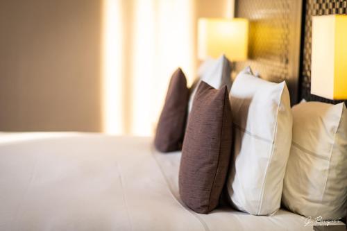 a group of pillows sitting on a bed at La Villa des Fleurs in Spa