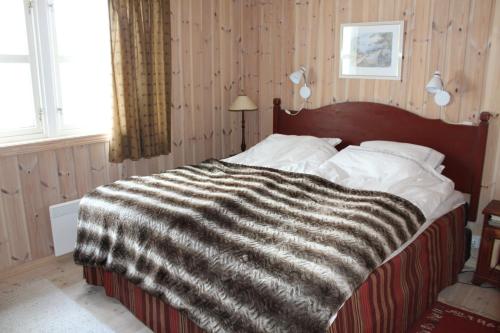 a bedroom with a bed with a black and white blanket at Magnesplass - Dagalifjell in Dagali