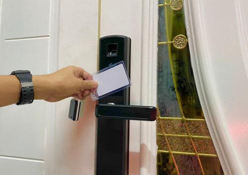 une personne ouvre une porte avec une carte dans l'établissement Landed Rayyan Homestay Gong Badak Kuala Nerus Free Wifi Full Aircond, à Kampong Pengkalan Maras