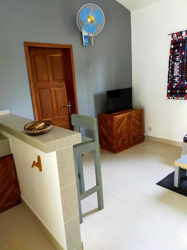 a room with a table and a chair and a fan at Oasis club in Cap Skirring