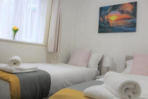 Clover Apartments في Hadleigh: غرفة معيشة بها سريرين وأريكة