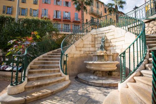 una escalera con una fuente frente a un edificio en Résidence Le Virginia by Popinns, en Grasse