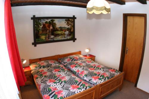 - une chambre avec un lit et une couette à fleurs dans l'établissement Soleil Wohnung, à Grächen