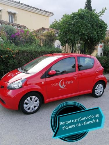 a small red car parked in a driveway at Studio Petit Amour in Sitio de Calahonda
