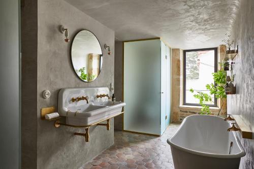 La salle de bains est pourvue d'un lavabo, d'une baignoire et d'un miroir. dans l'établissement La Maison de Pommard, à Pommard