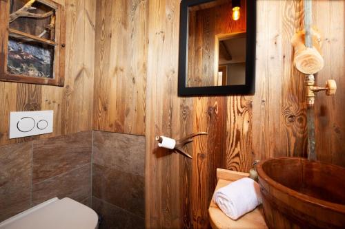 La salle de bains est pourvue de toilettes et d'un mur en bois. dans l'établissement Alpenpension Ettlerlehen Ferienwohnungen, à Ramsau bei Berchtesgaden