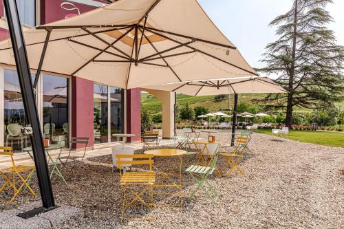 a group of tables and chairs with umbrellas at L'aja della Mirusina - Piedmont Resort Monferrato Langhe in Canelli