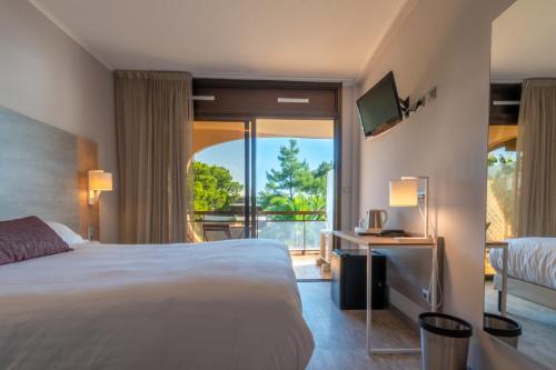 a hotel room with a bed and a balcony at Hôtel Bahia in Villeneuve-Loubet