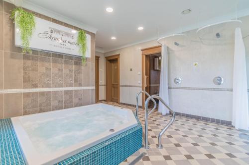 a hot tub in a bathroom with a tiled floor at Skrunda Manor in Skrunda