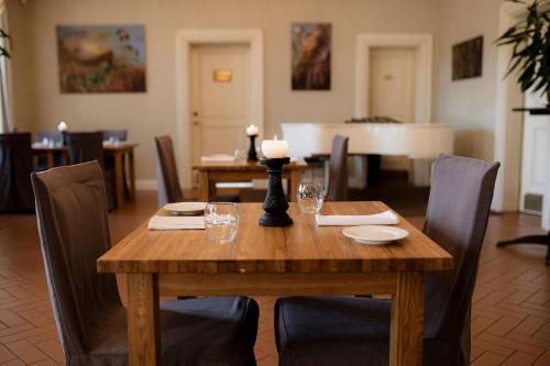 a wooden table with chairs and a candle on top at Skrunda Manor in Skrunda