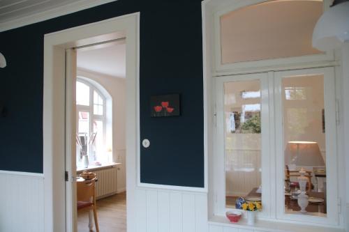 Zimmer mit einer Tür und einer Wand mit einem Fenster in der Unterkunft Pension Hilligenlei Zi 01 EZ in Wyk auf Föhr