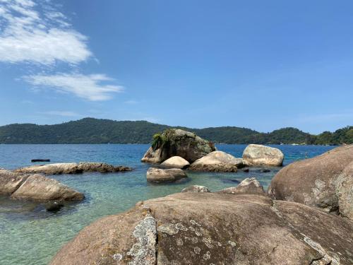 a group of rocks in a body of water at Angra House - Linda Casa em ILHA in Angra dos Reis