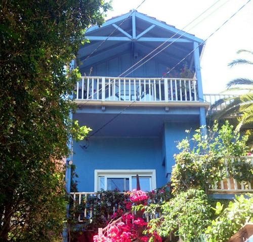 a blue house with a balcony and flowers at TREETOPS PENTHOUSE Rose Bay Sydney, 3 bedrooms in Sydney