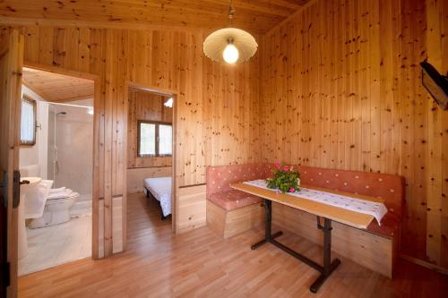 um quarto de madeira com um banco e uma casa de banho em Casa Rododendro em Barzio