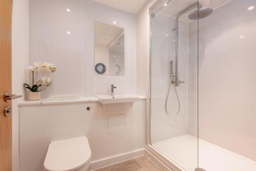 a white bathroom with a shower and a sink at Deluxe New Park Place Apartment - Parking in St. Andrews