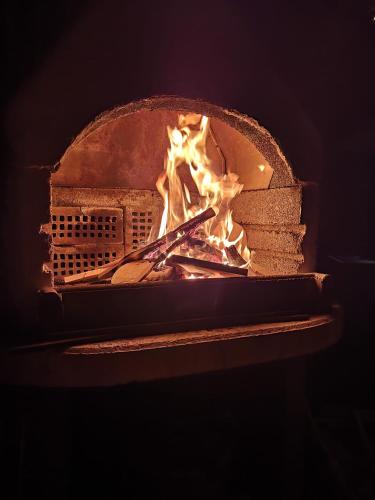 a brick oven with a fire in it at Ferienwohnung Haus am Bach in Toggenburg in Wildhaus
