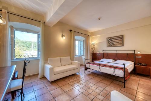 a bedroom with a bed and a chair and a table at Hotel Splendido in Kotor