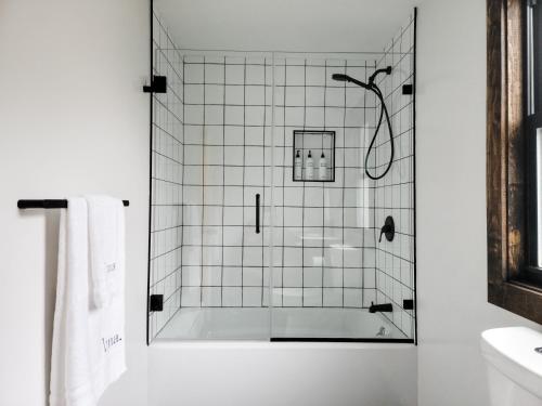 een douche met een glazen deur in de badkamer bij Black Pearl Unit 1 - Lake Placid, Mirror Lake in Lake Placid