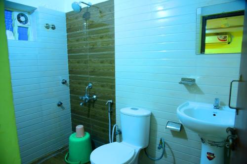 a bathroom with a toilet and a sink at Hotel Housefinch Residency in Bengaluru