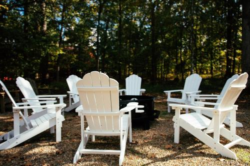 a group of white chairs sitting in the grass at Fishers of Zen - Broken Bow Vacation Cabin in Broken Bow