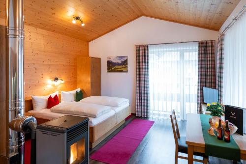 a bedroom with a bed and a table and a desk at Ferienwohnung Heidi in Elmen