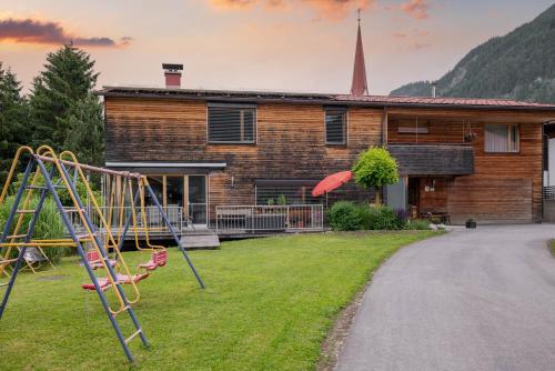 a playground in front of a house with a church at Ferienwohnung Heidi in Elmen