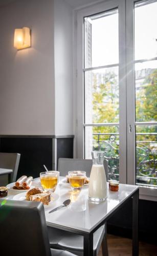- une table avec de la nourriture et des boissons avec 2 fenêtres dans l'établissement Hôtel du Parc Montparnasse, à Paris