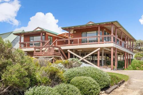 a log home with a wrap around deck at Red Door - Enjoy Exclusive Front Row Sunsets from the Balcony & Walks to the Surf in Gnarabup in Gnarabup