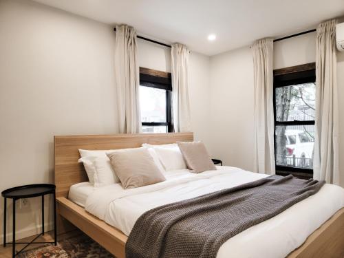 1 dormitorio con 1 cama grande con sábanas blancas y ventanas en Black Pearl Unit 2 - Lake Placid, Mirror Lake en Lake Placid