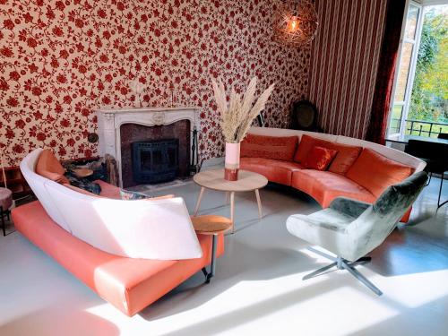 ein Wohnzimmer mit einem roten Sofa und einem Stuhl in der Unterkunft Château de la Combe in La Celle