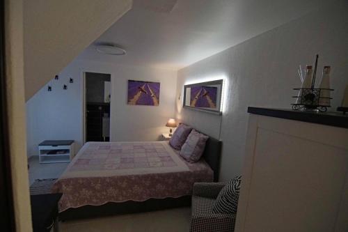 um pequeno quarto com uma cama num quarto em Chez Amali em Brignoles