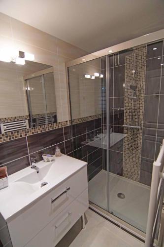 La salle de bains est pourvue d'un lavabo et d'une douche avec une porte en verre. dans l'établissement Chez Amali - Élégant appartement de vacances en Provence avec terrasse, à Brignoles