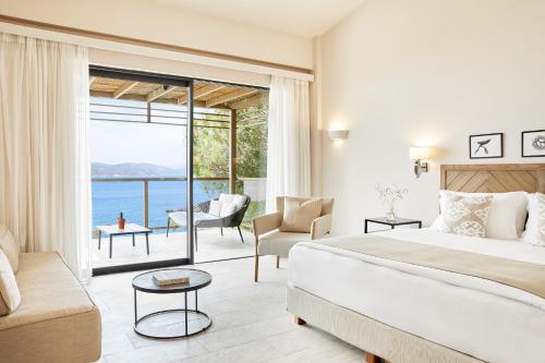 a bedroom with a bed and a view of the ocean at ELIVI Skiathos in Koukounaries
