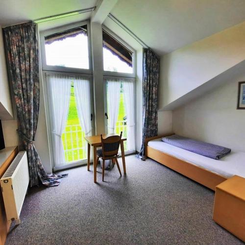 a bedroom with a bed and a desk and a window at Landhotel Albrecht in Missen-Wilhams