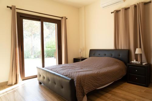 1 dormitorio con cama y ventana grande en Zangoulos Mountain, en Kakopetria
