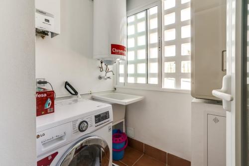 a laundry room with a washer and a sink at Kaki in San Juan de los Terreros