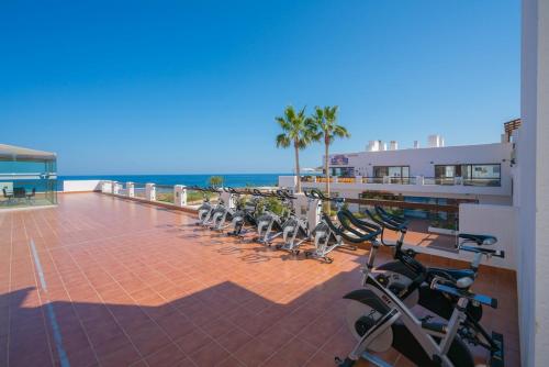 a row of exercise bikes parked next to the beach at Apartment Chendula in San Juan de los Terreros