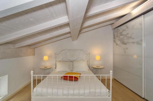 a bedroom with a white bed with two lamps at Villino Ermione in Marina di Pisa
