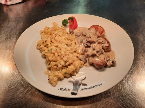 a plate of food with rice and a goat on it at Landhotel Albrecht in Missen-Wilhams
