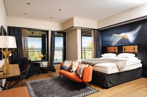 ヨエンスーにあるオリジナル ソコス ホテル キンメル ヨエンスーのベッドルーム(キングサイズベッド1台付)、リビングルームが備わります。