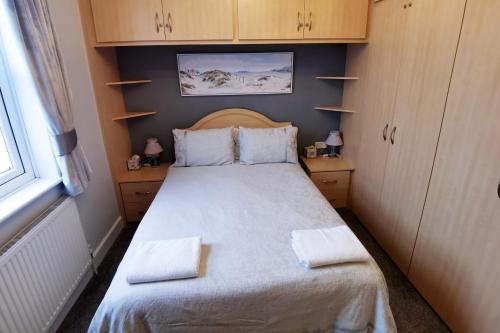 a small bedroom with a bed with two towels on it at Avoncot Guest House in Stratford-upon-Avon