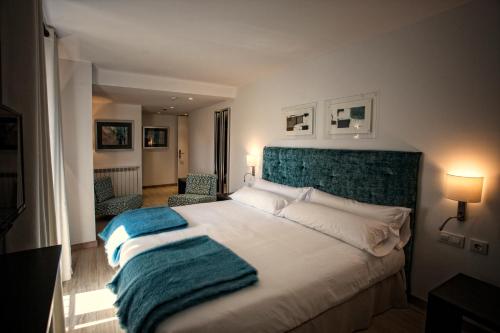 a bedroom with a large bed with a green headboard at Hotel Pura Vida in Valgañón