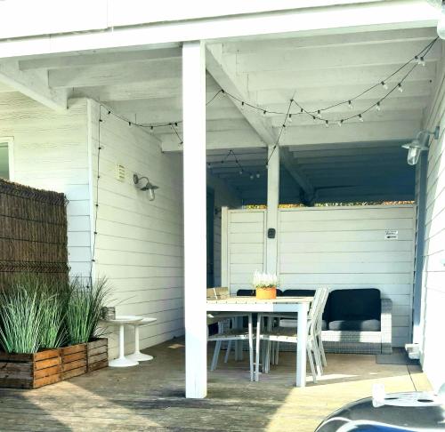 - une table et des chaises blanches sur la terrasse dans l'établissement Cottage du Lac Studio, à Nivezé