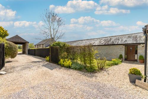 a driveway leading to a house with a fence at The Old Stables in Yeovil