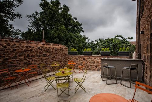 a patio with chairs and tables and a brick wall at Hotel Pura Vida in Valgañón