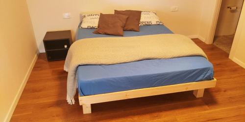 a bed with a blue blanket and pillows on it at Beit Kedem 